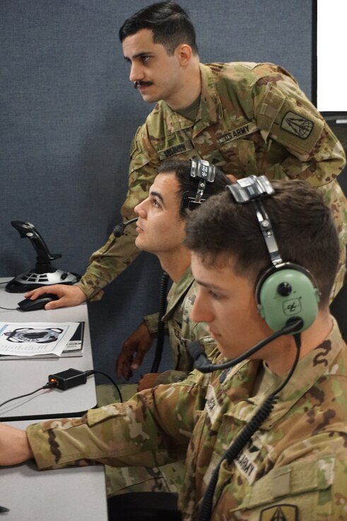  Alt text: uniformed military members work on computers