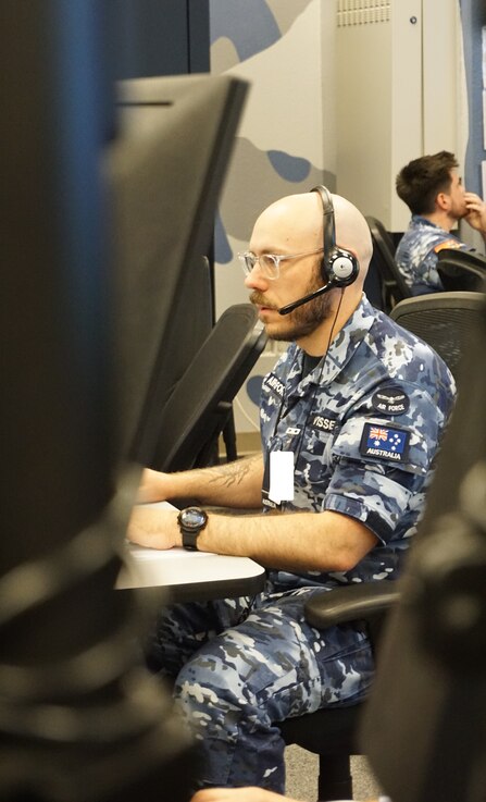  Alt text: uniformed military members work on computers
