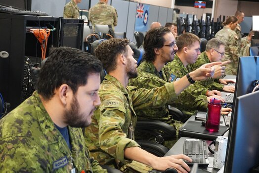  Alt text: uniformed Royal Canadian military members working at computers