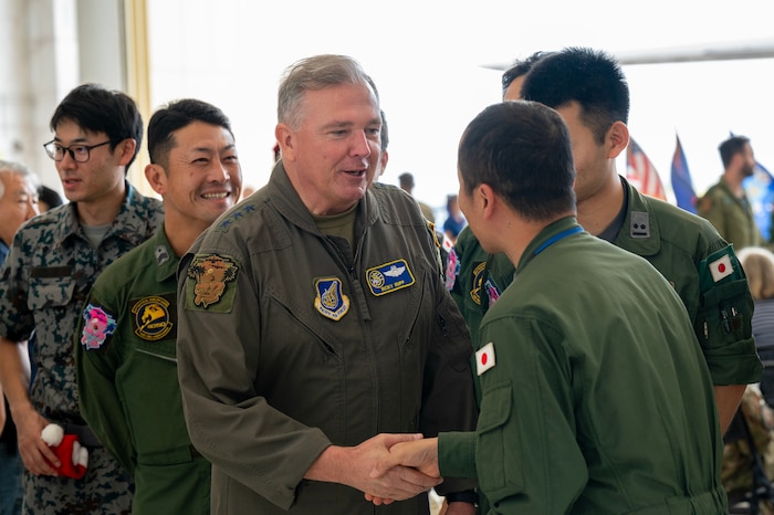 Photo of U.S. Air Force leader exchanging coins with a 
JASDF leader