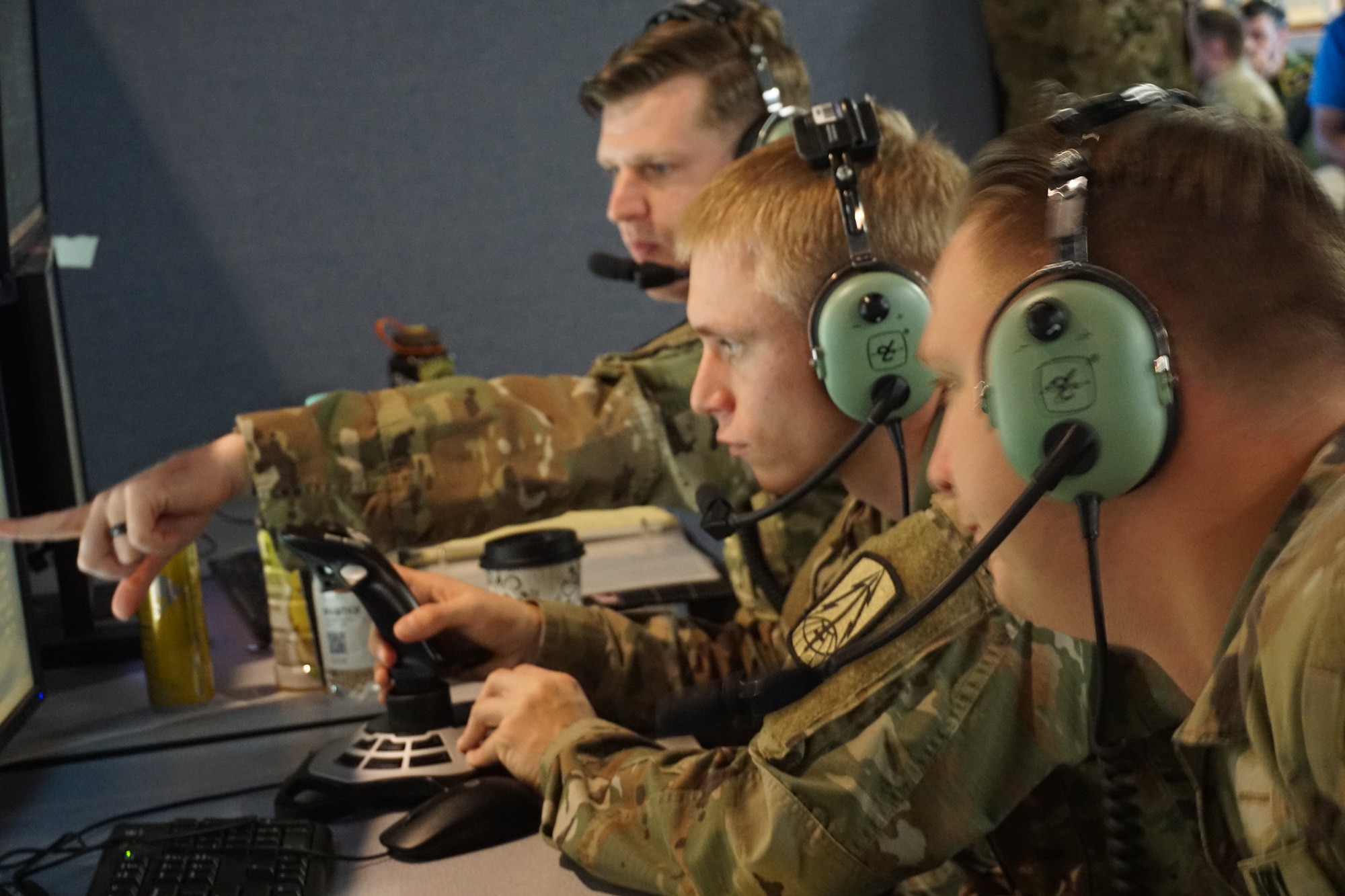 Alt text: uniformed military members work on computers