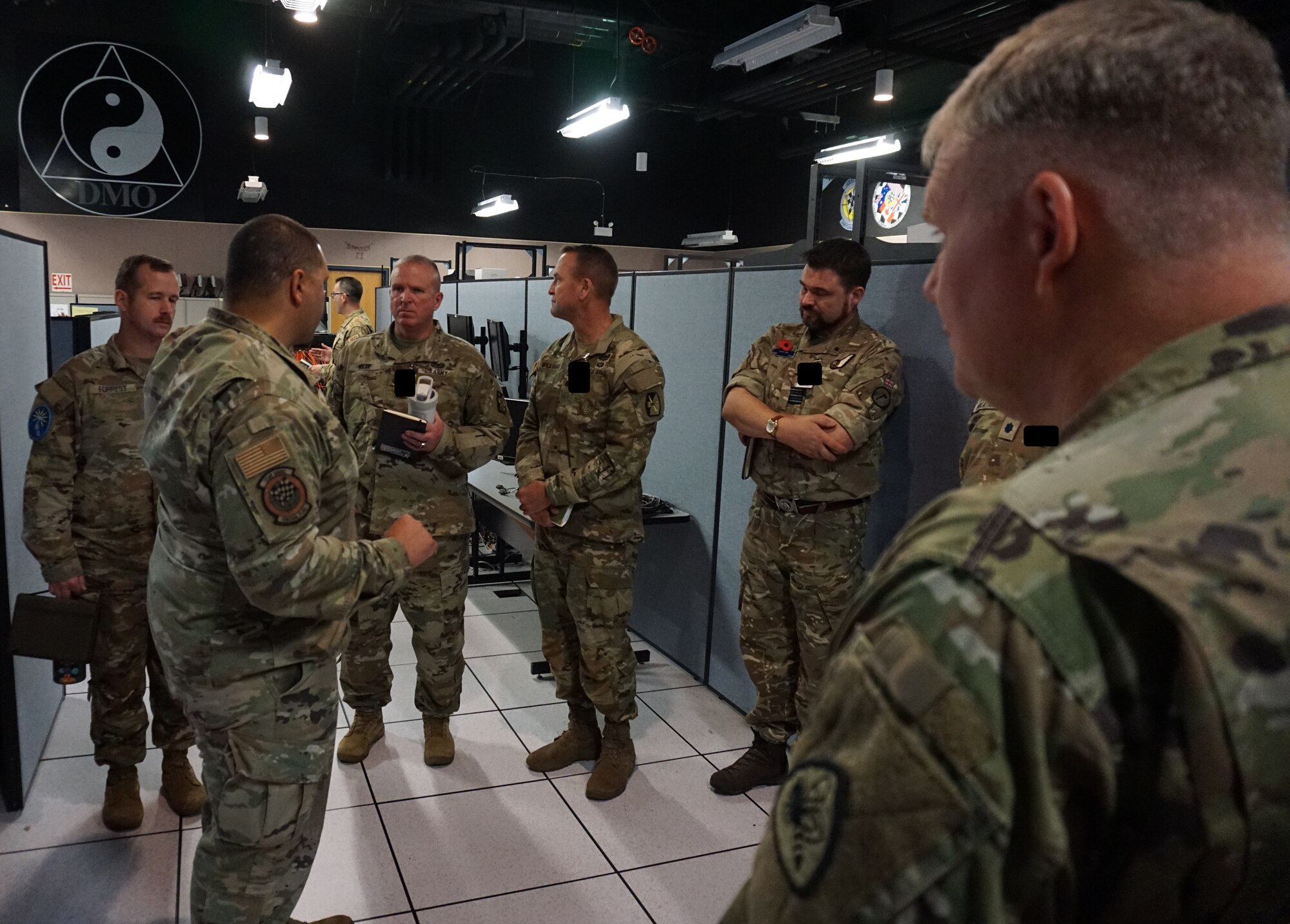 uniformed military members talk while standing in semicircle