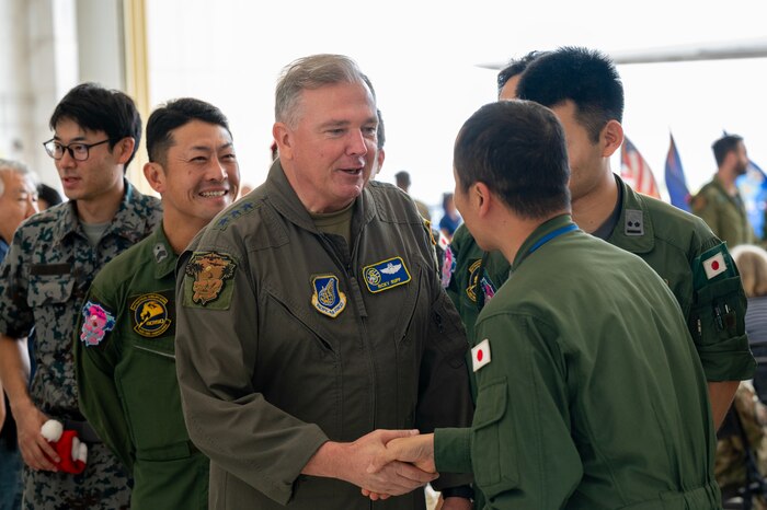 Photo of U.S. Air Force leader exchanging coins with a 
JASDF leader