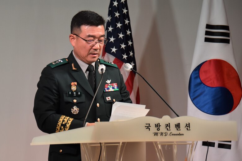 Maj. Gen. Jo, Byung-yoon, commanding general, ROK Ministry of Defense – Defense Installations Agency, delivers remarks from a podium during a ceremony.