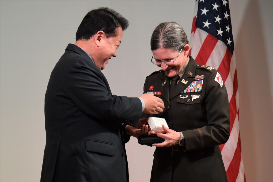 Congressman Kim Byung-joo, Member of the National Assembly of the Republic of Korea and Former Deputy Commander of the Combined Forces Command, presents Col. Heather Levy, commander, U.S. Army Corps of Engineers - Far East District, with new business cards during a ceremony.