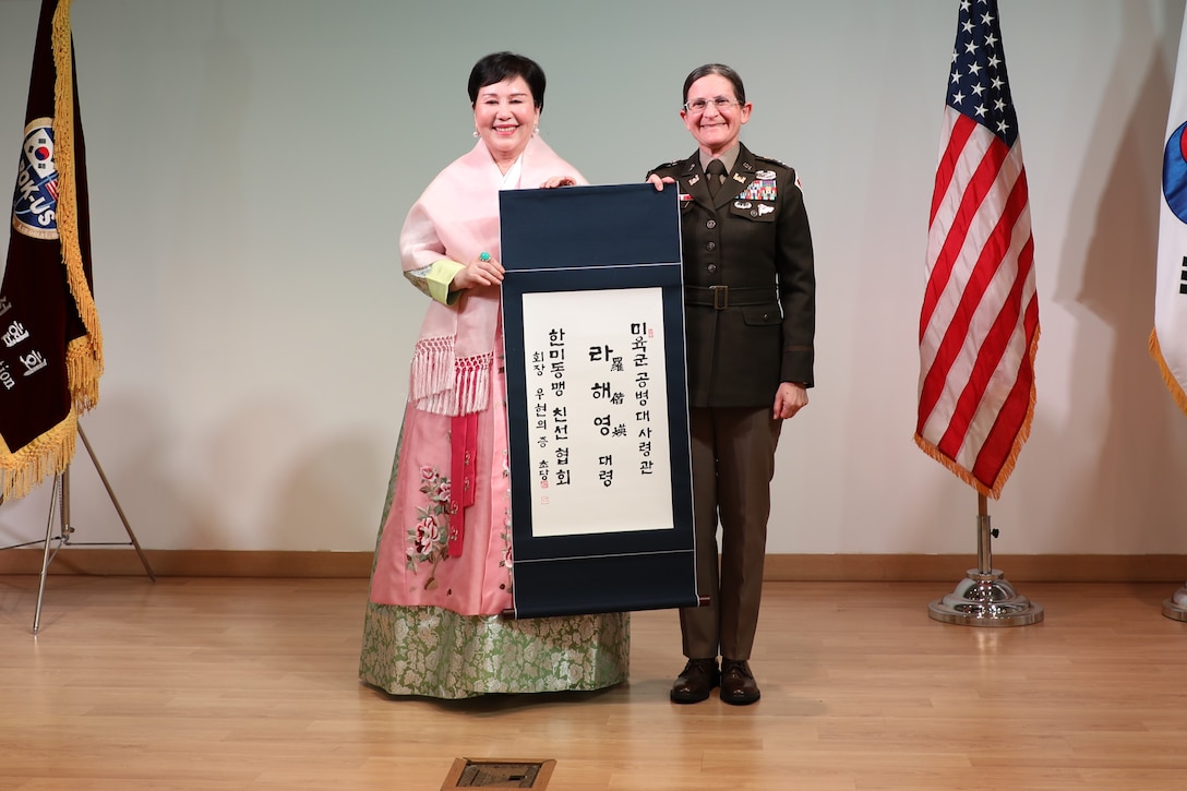 Ms. Woo, Hyun-euy, chairperson, Republic of Korea-U.S. Alliance Friendship Association, presents Col. Heather Levy, commander, U.S. Army Corps of Engineers - Far East District, with a traditional Korean name written on a scroll.