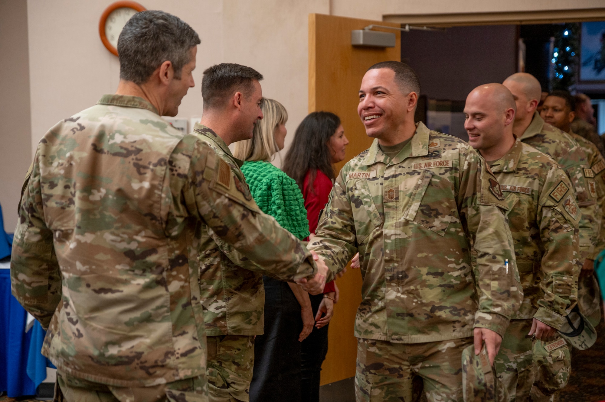 U.S. Air Force Col. William McKibban, 51st Fighter Wing commander, greets U.S. Air Force Chief Master Sgt. Marques Martin, 51st Logistics Readiness Squadron deployment and distribution flight chief, during the holiday reception at Osan Air Base, Republic of Korea, Dec. 6, 2023.
