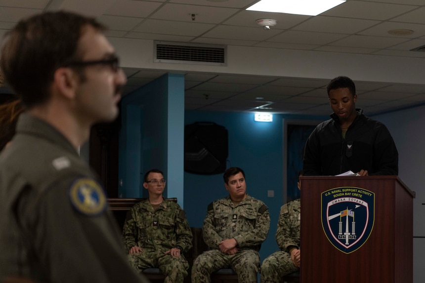 Boatswain’s Mate 3rd Class Jermaine Myers, assigned to Naval Support Activity Souda Bay, recounts the ships damaged during the 1941 attack on Pearl Harbor during a Pearl Harbor Remembrance Day Ceremony in The Anchor on Dec. 7, 2023.
