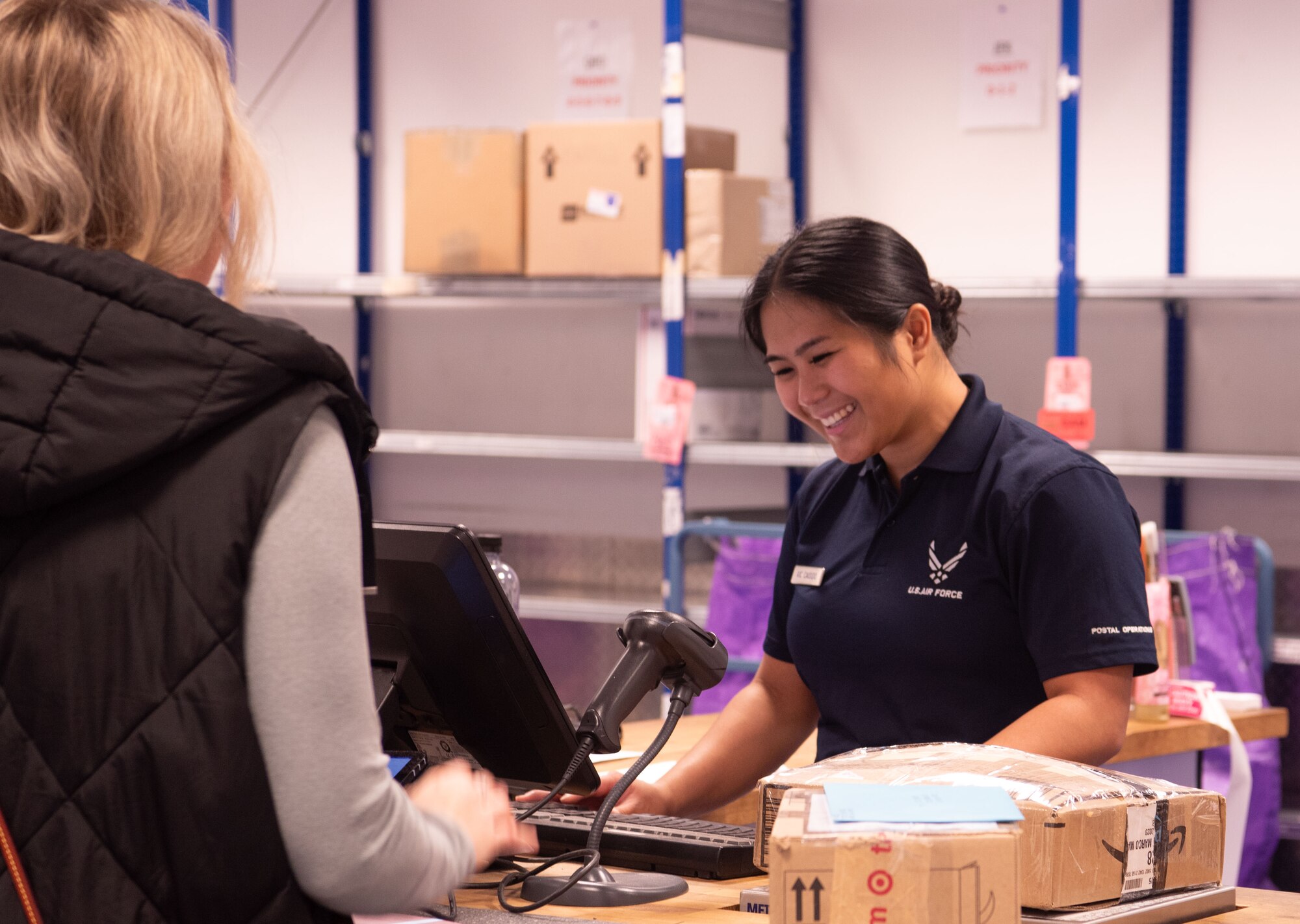 a woman helps a postal costumer