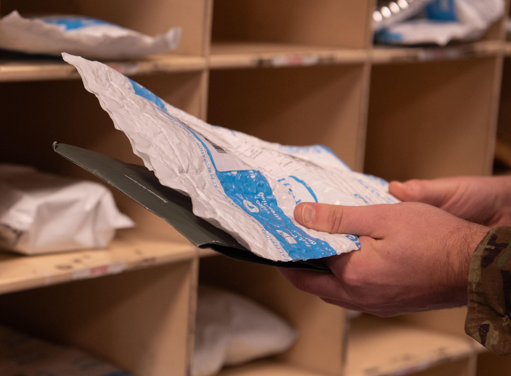A postal worker sorts various packages into the electronic email notification system at the Northside Post Office