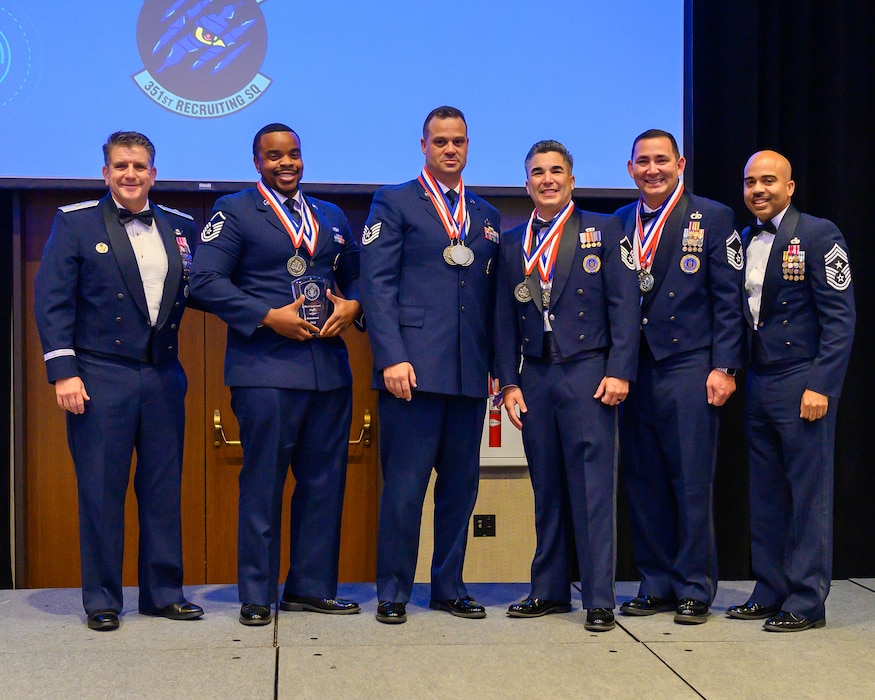 Brig Gen Christopher Amrhein and AFRC Command Chief Israel Nuñez present the Most Improved Flight award to MSgt Erick Williams, TSgt Bryant Guardia, MSgt Jaime Gomez Lopez, and SMSgt Chase Kaiuwailani during the 367th Recruiting Group Awards ceremony. This prestigious award recognizes the team's exemplary achievement of an 83% increase in recruitments in Fiscal Year 23, underscoring their significant contribution to the Air Force Reserve Command's recruitment efforts. (U.S. Air Force photo by Master Sgt. Bobby Pilch)