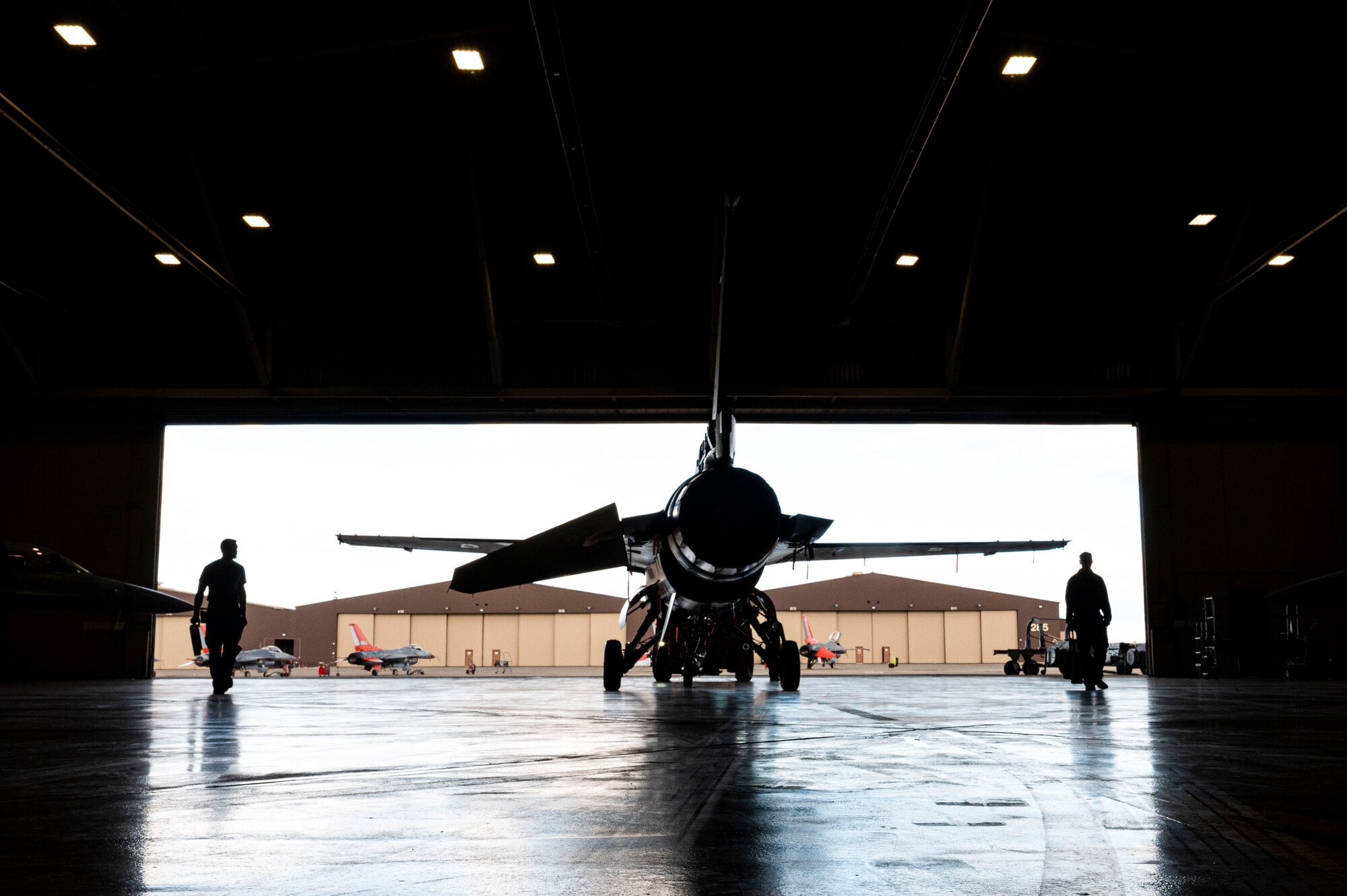 Airmen from the 49th Equipment Maintenance Squadron phase section tow an F-16 Viper for inspection at Holloman Air Force Base, New Mexico, Dec. 1, 2023. The 49th EMS phase section is responsible for providing thorough inspections of all F-16s  before and after flight operations. (U.S. Air Force photo by Airman 1st Class Isaiah Pedrazzini)