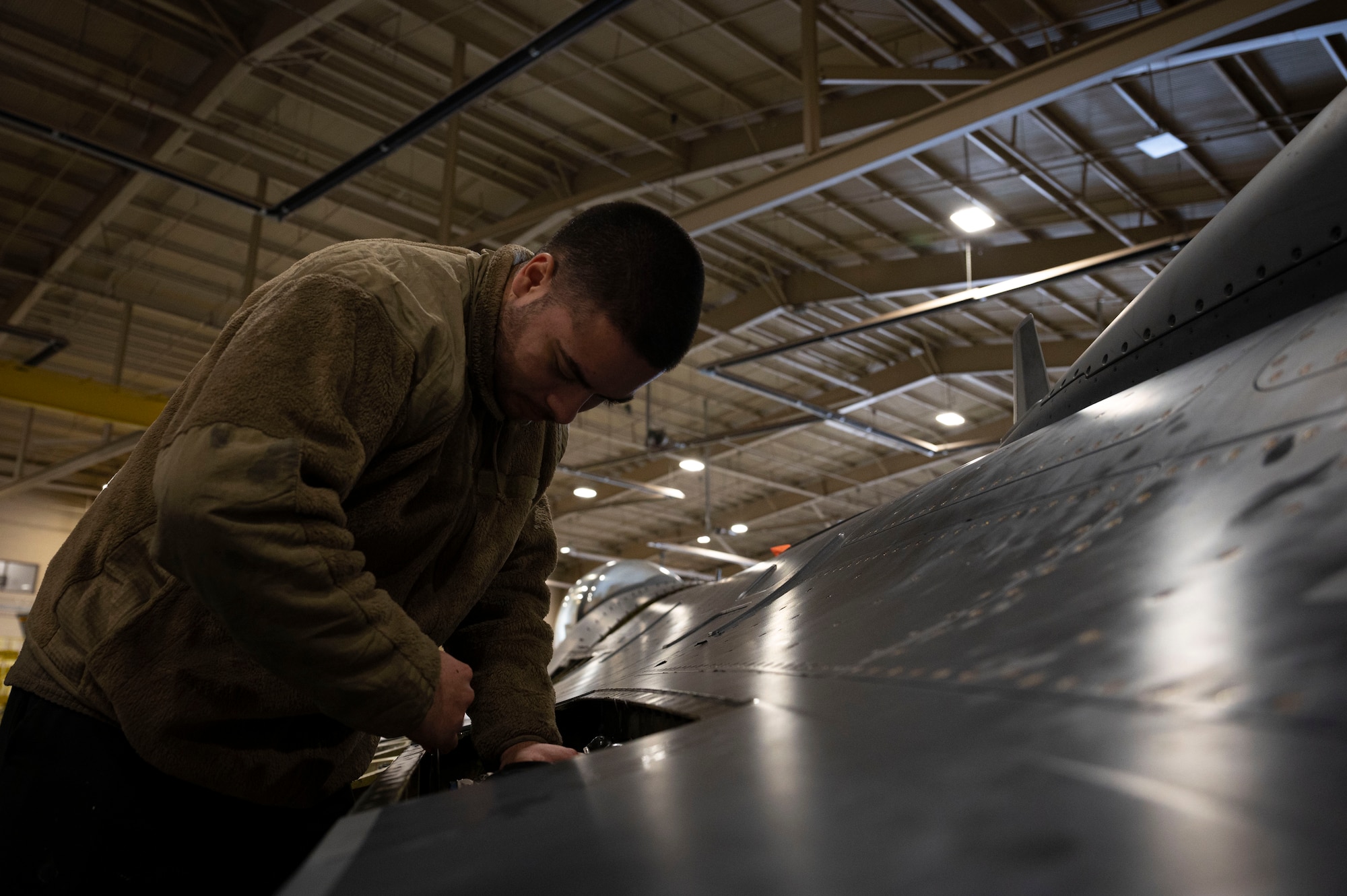 U.S. Air Force Senior Airman Andres Medrano, 49th Equipment Maintenance Squadron aircraft inspection section journeyman, performs an inspection of a wing component on an F-16 Viper at Holloman Air Force Base, New Mexico, Dec. 1, 2023. Phase inspections are performed with high attention to detail to ensure all F-16s are ready for operational use. (U.S. Air Force photo by Airman 1st Class Isaiah Pedrazzini)