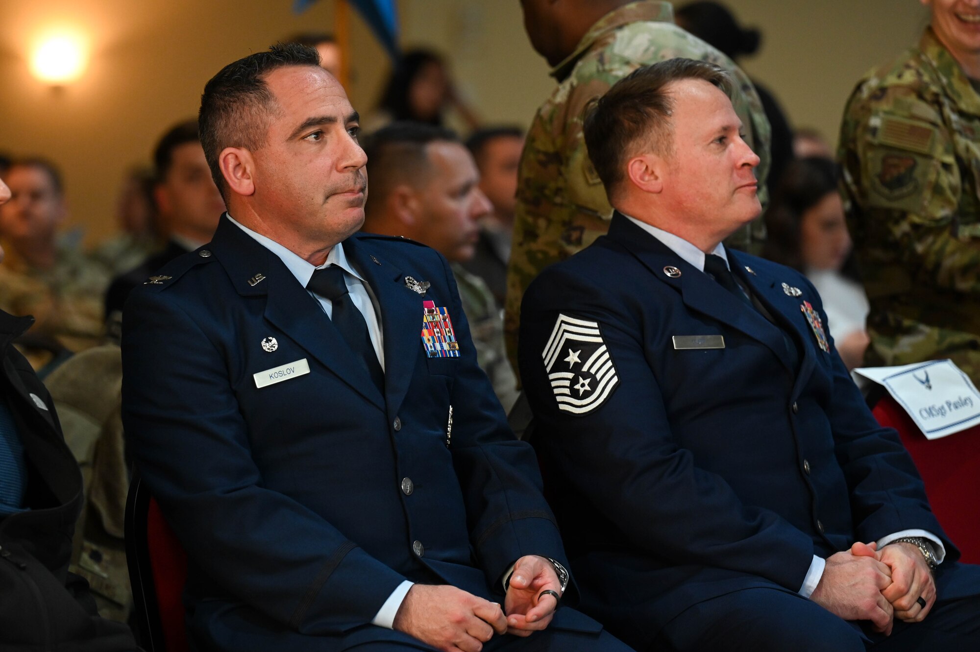 U.S. Air Force Col. Josh Koslov, 350th Spectrum Warfare Wing commander, left, and U.S. Air Force Chief Master Sgt. Will Cupp, 350th SWW command chief, right, attend the Airman Leadership School Class 24-Alpha graduation ceremony at Eglin Air Force Base, Fla., Dec. 7, 2023. The 350th SWW sponsored class 24-A and had the opportunity to speak to the students during their course, present the awards at graduation and give closing remarks. (U.S. Air Force photo by Capt. Benjamin Aronson)