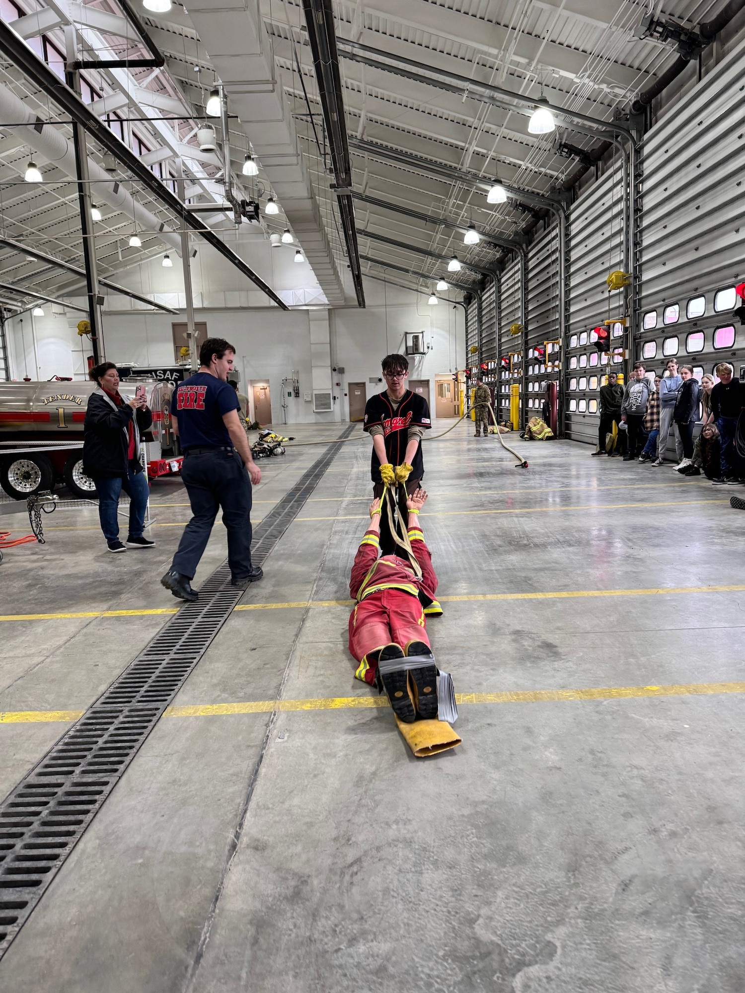 A student from Douglas Middle School practices a body drag technique using a mannequin during a base tour at the 28th Civil Engineer Squadron fire department at Ellsworth Air Force Base, South Dakota, Dec. 5, 2023.