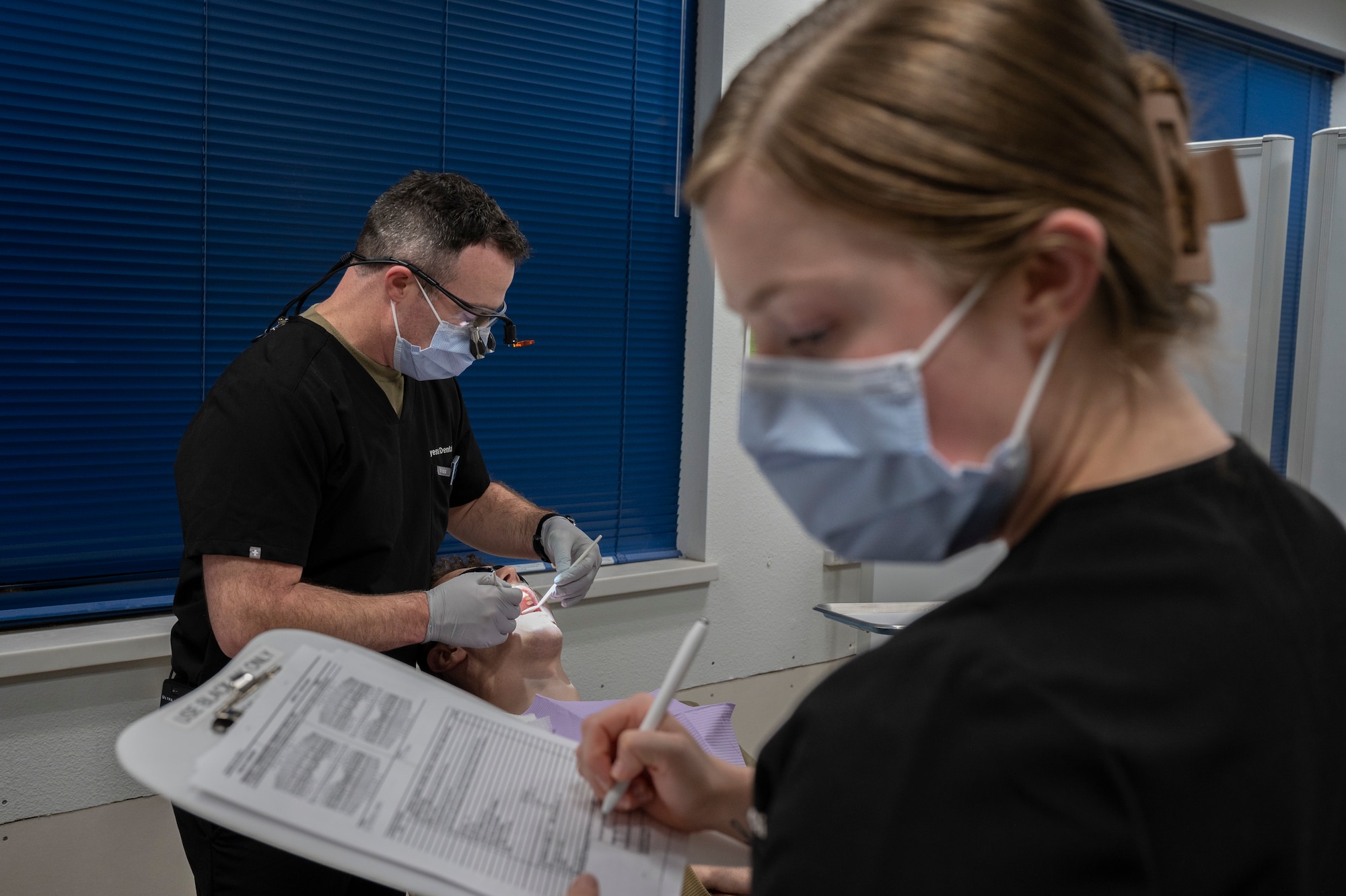 U.S. Air Force Capt. Gabriel Duffy, 7th Operations Medical Readiness Squadron dental flight dentist, and Senior Airman Kyra Hensen, 7th OMRS dental flight dental assistant, perform a dental exam on Airman 1st Class Kyle Vandergriff, 317th Aircraft Maintenance electrical and environmental technician, in the Mobile Dental Clinic at Dyess Air Force Base, Texas, Nov. 30, 2023. This new Mobile Dental Clinic capability allows patients to cut down on the amount of time spent away from their duty sections for dental exams as well as operating in an environment and time that works best for the patient. (U.S. Air Force photo by Airman 1st Class Alondra Cristobal Hernandez)