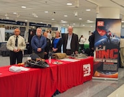 Photo of people standing at a tabel. In October, Laura Riddle, UESC project director,  Martha Kiene, Fort Belvoir Power Reliability Enhancement Program Chief,  Harry Goradia, HQ USACE engineer,  Keith Tyler, HQ USACE resource efficiency manager, and Charles Heimer, Huntsville Center REM, manned an exhibit at the Pentagon during Energy Action Month to bring awareness to available programs that reduce energy cost and consumption.