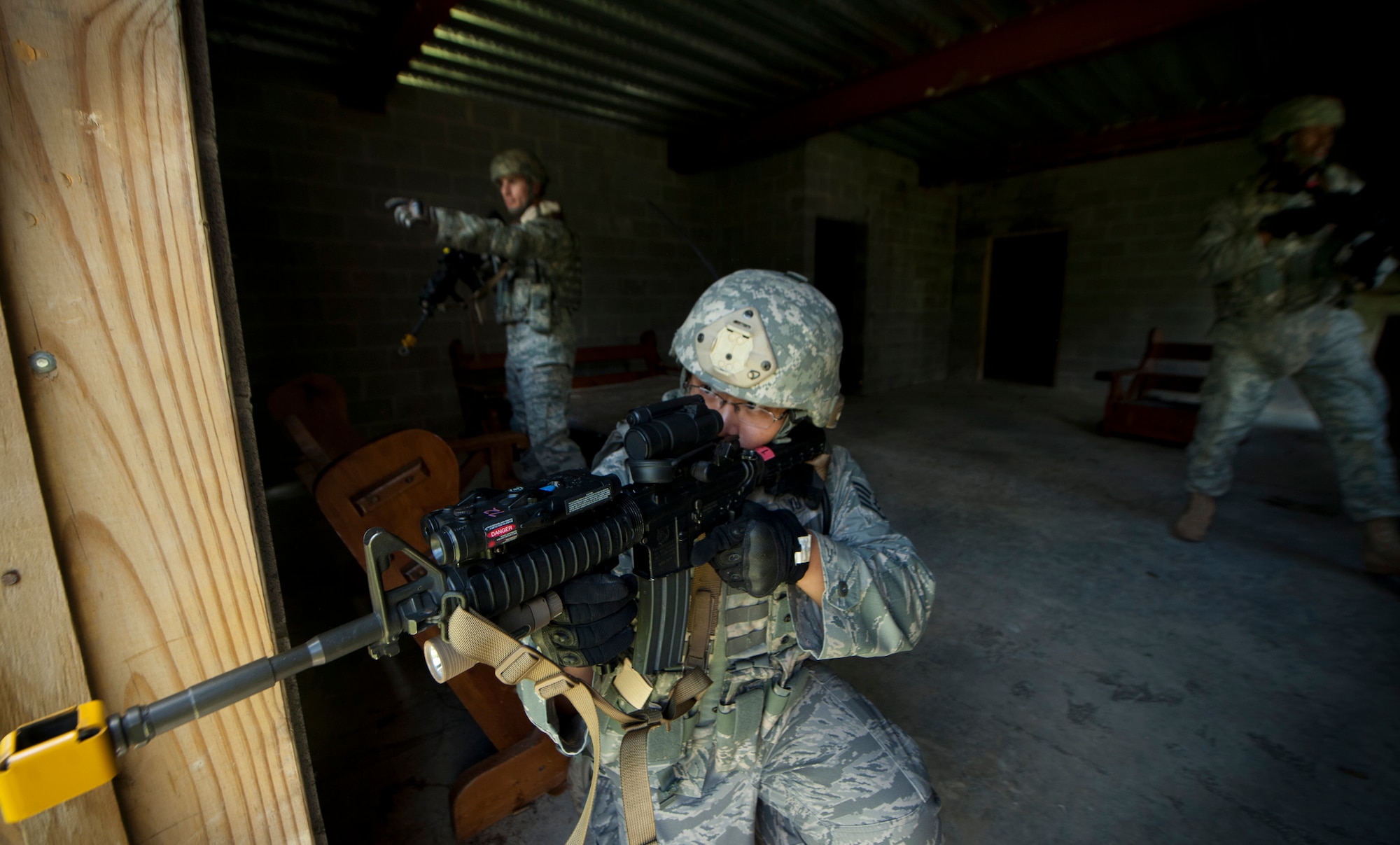 U.S. Air Force Staff Sgt. Andrew Yu, 823rd Base Defense Squadron training NCO, prepares to return fire on opposing forces during a scenario for the squad leadership course at Moody Air Force Base, Ga., July 29, 2011. Sergeant Yu and members from his squad were tasked to meet with the village leader to exchange information, take on opposing forces and secure the village. (U.S. Air Force photo by Airman 1st Class Joshua Green)