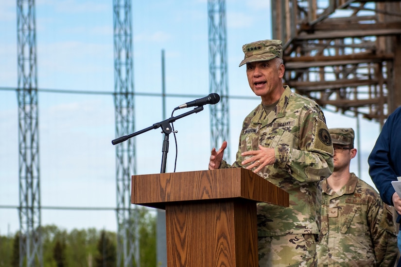 A man in uniform stands at a lectern.