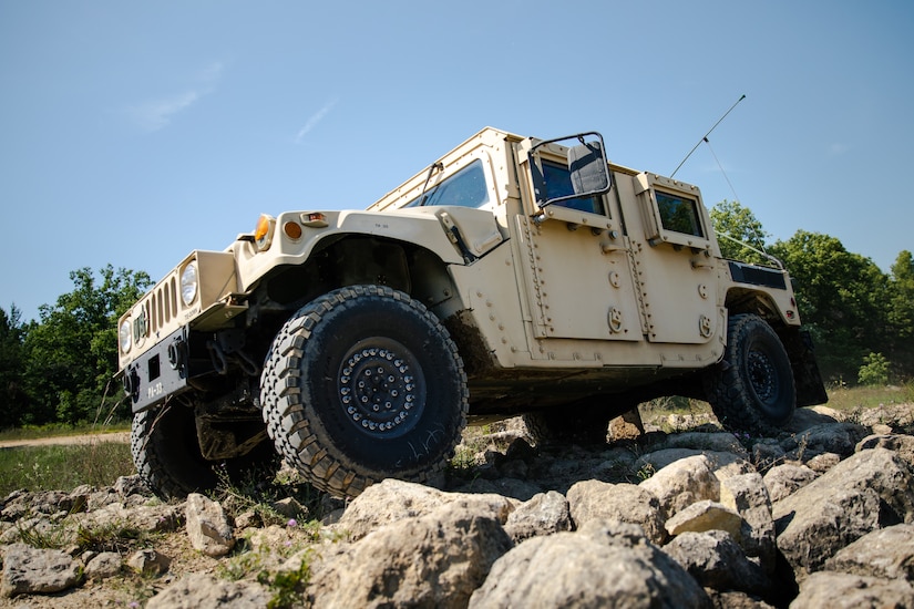 A Humvee travels over rocky terrain.