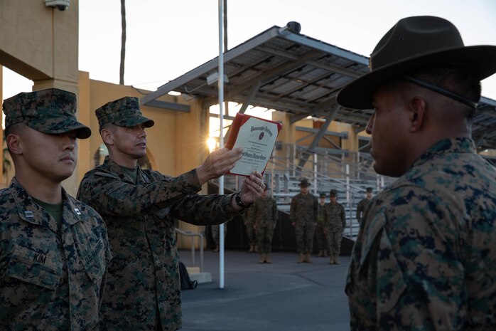 Sgt. Maj. Carlos Ruiz, the 20th Sergeant Major of the Marine Corps, reads the reenlistment warrant for Sgt. Oscar Aguilar, a drill instructor with Fox Company, 2nd Recruit Training Battalion, at Marine Corps Recruit Depot San Diego, Dec.5, 2023. Ruiz visited the Depot to listen to the ideas, questions, and concerns of Marines throughout the installation on how to improve the Marine Corps and recruiting mission. (U.S. Marine Corps photo by Lance Cpl. Sarah M. Grawcock)
