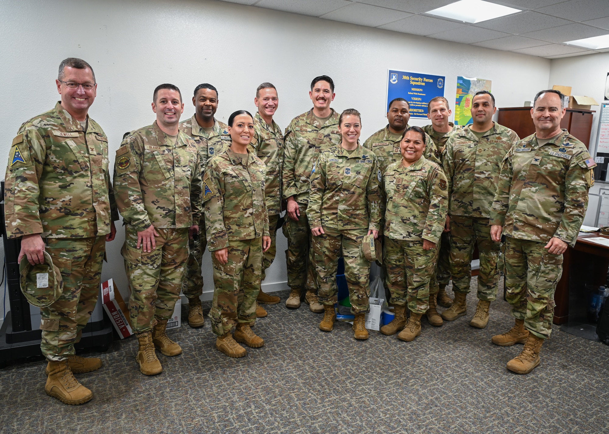 Space Launch Delta 30 commander, along with base leadership pose for a group photo with 30th Security Forces Squadron operations superintendent, at Vandenberg Space Force Base.