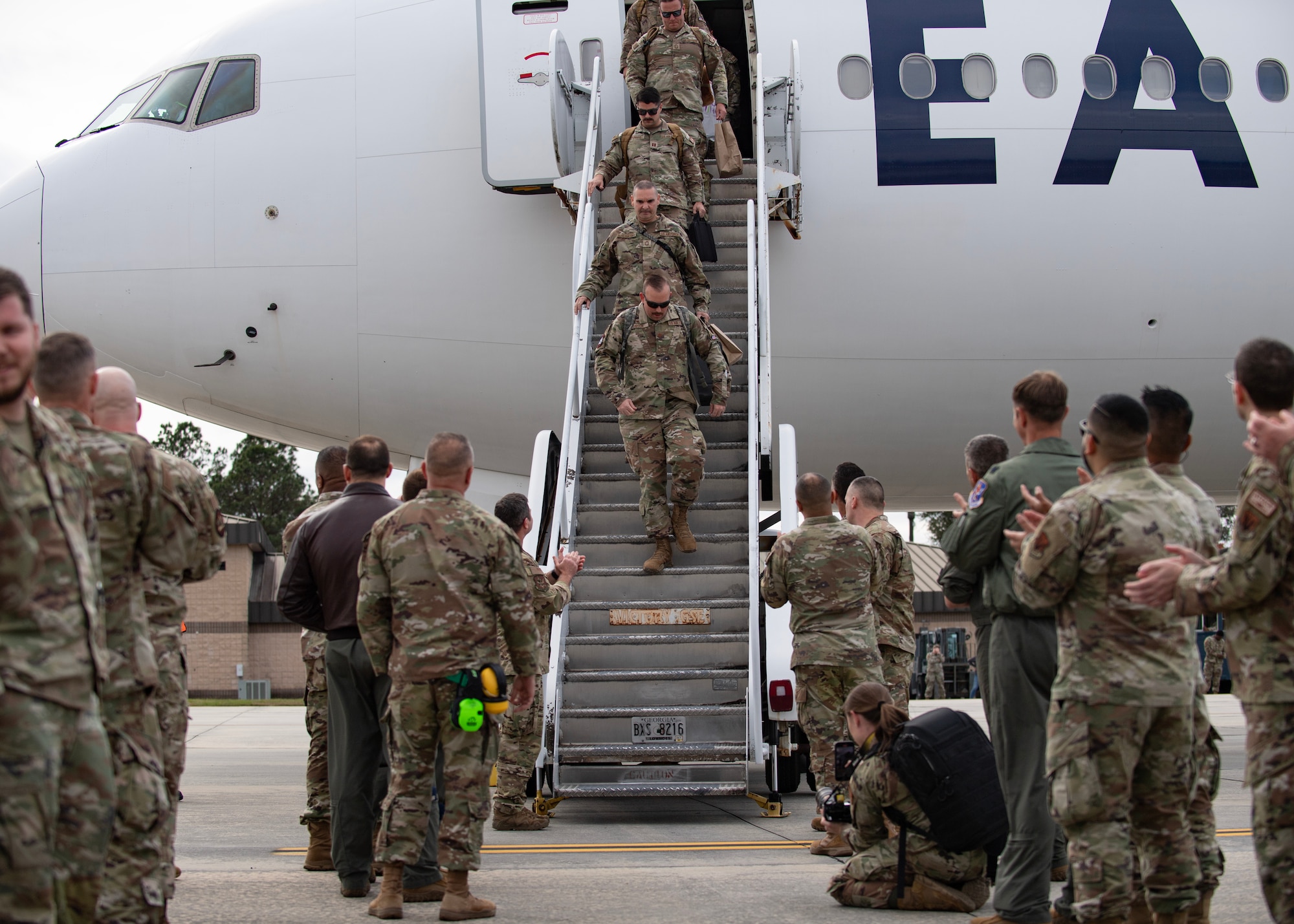 A group of Airmen deboard a plane