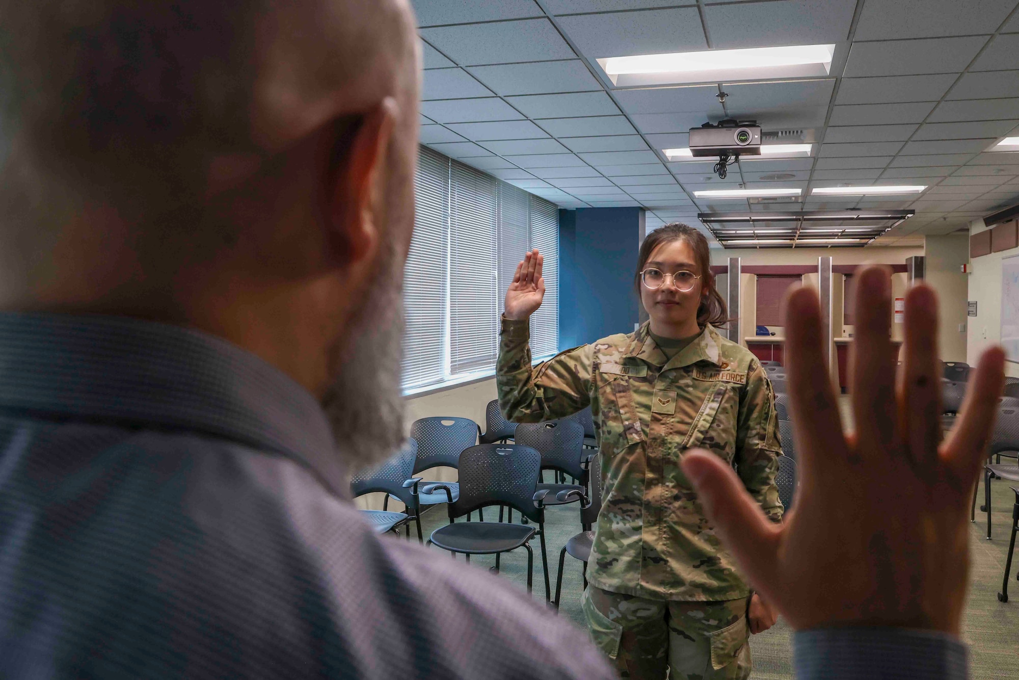 U.S. Air Force Airman 1st Class Trieu Do, 9th Force Support Squadron food service specialist, raises her hand to recite the Oath of Allegiance at the United States Citizenship and Immigration Services field office in Sacramento, California, Nov. 15, 2023.