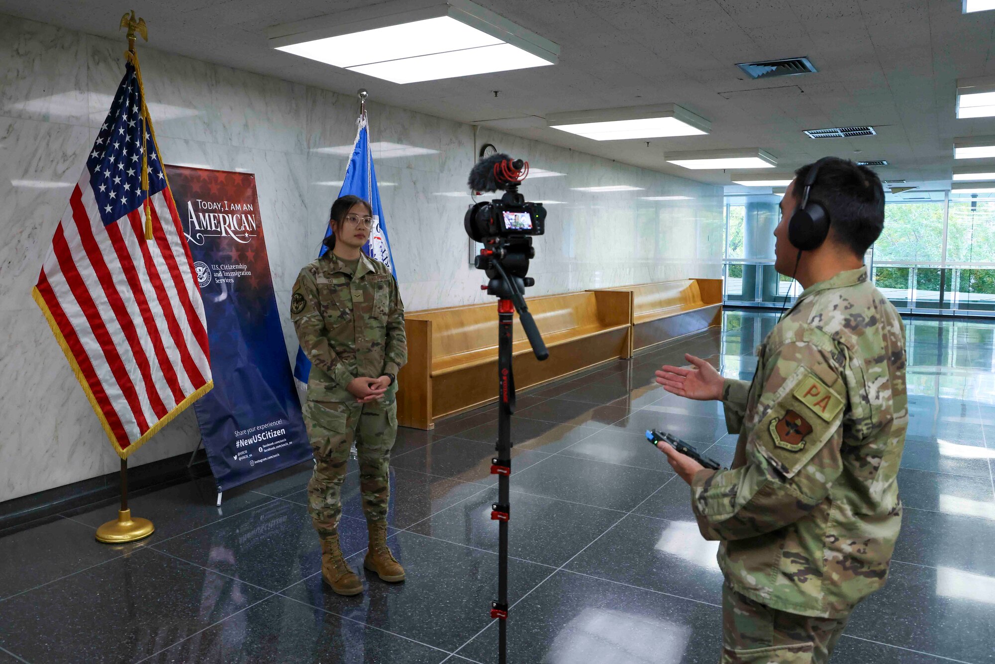 U.S. Air Force Airman 1st Class Trieu Do, 9th Force Support Squadron food service specialist, is interviewed by U.S. Air Force Staff Sgt. Ramon Adelan, 364th Recruiting Squadron public affairs specialist, after conducting her nationalization ceremony to become a U.S. citizen at the United States Citizenship and Immigration Services field office in Sacramento, California, Nov. 15, 2023.