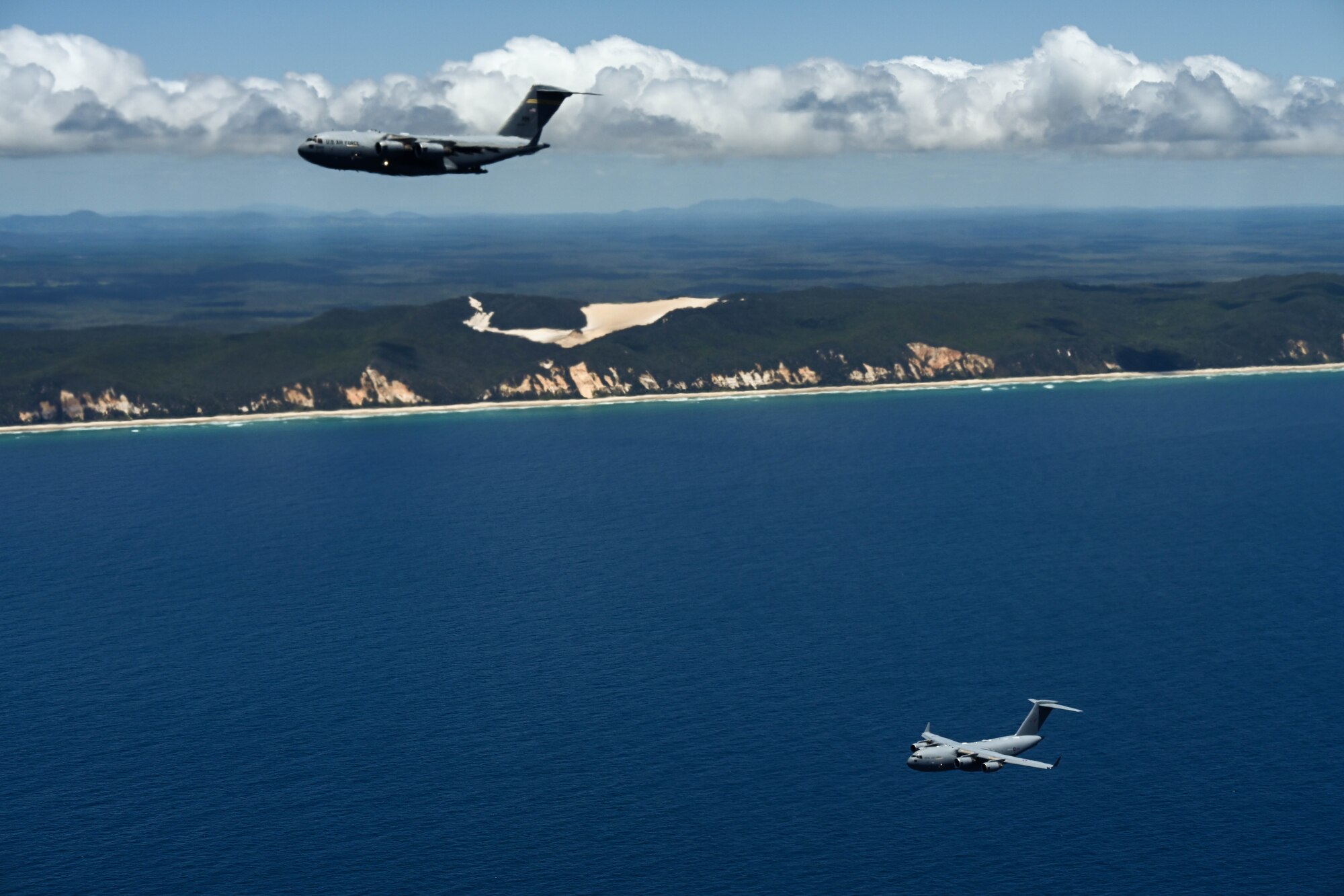 U.S. Air Force and Royal Air Force C-17 Globemaster IIIs participate in a training flight alongside the Royal Australian Air Force during Exercise Global Dexterity 23-2 in the skies of Australia, Dec. 8, 2023. Exercise Global Dexterity allows our air forces to execute bilateral interoperability with blended aircrews between the RAAF and the USAF. (U.S. Air Force photo by Senior Airman Makensie Cooper)