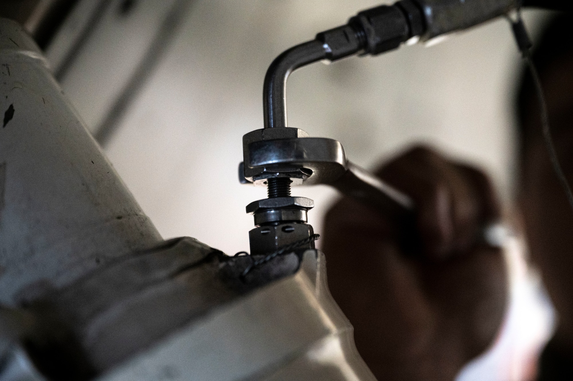 An Airman from the 49th  Equipment Maintenance Squadron phase section prepares to drain the hydraulic fluid of an F-16 Viper at Holloman Air Force Base, New Mexico, Dec. 1, 2023. The 49th EMS phase section inspects all aspects of an F-16, from exterior to interior, in order to check for any damage or infractions that would jeopardize the aircrafts stability in the sky. (U.S. Air Force photo by Airman 1st Class Isaiah Pedrazzini)
