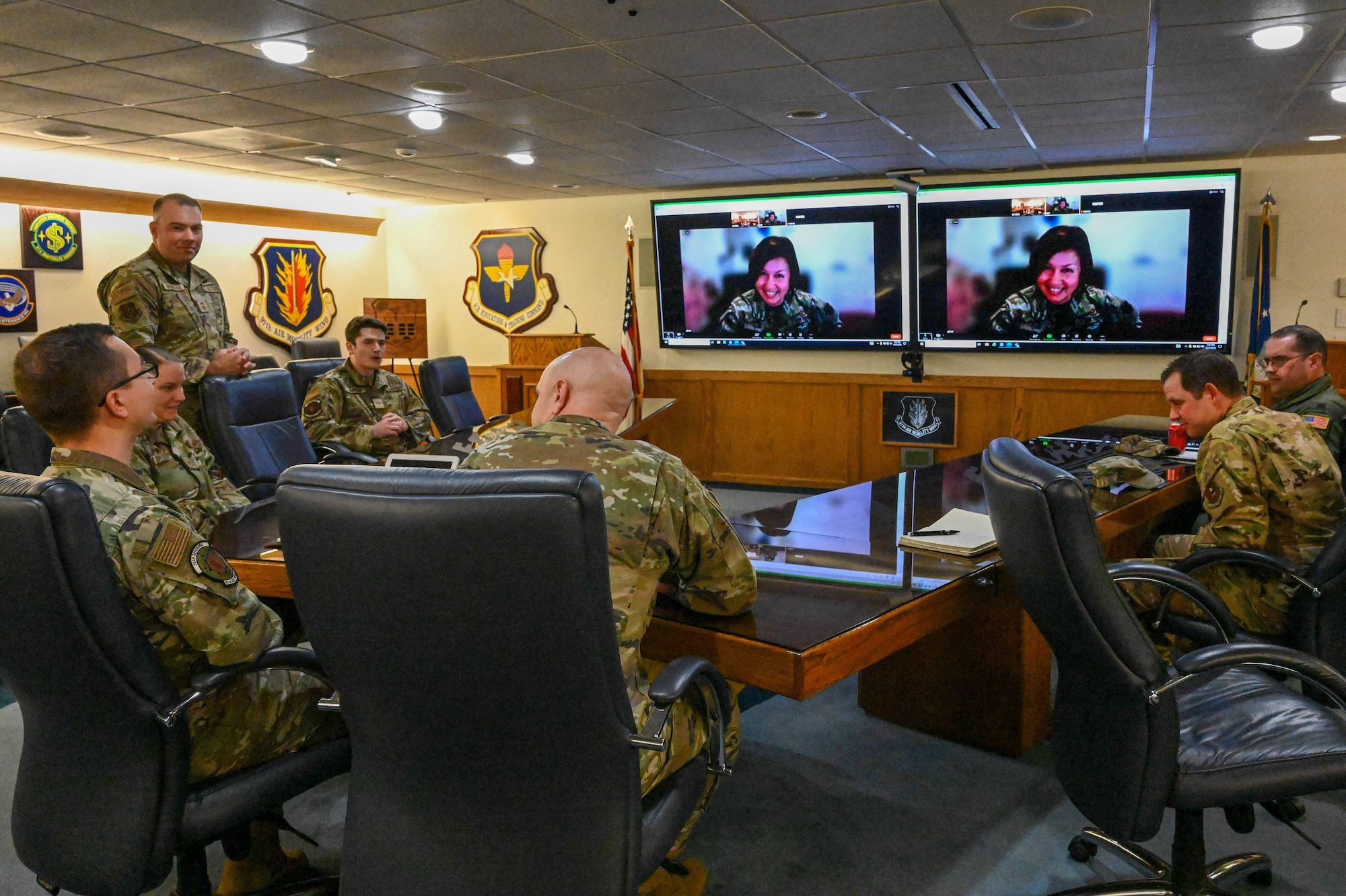Chief Master Sgt. of the Air Force JoAnne S. Bass greets 97th Air Mobility Wing Airmen over a video call at Altus Air Force Base, Oklahoma, Nov. 21, 2023. During the call, Bass announced one of her two annual selections for the Senior Leadership Enlisted Commissioning Program. (U.S Air Force by Senior Airman Miyah Gray)
