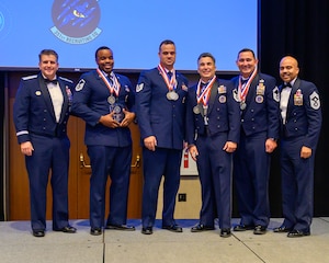 Brig Gen Christopher Amrhein and AFRC Command Chief Israel Nuñez present the Most Improved Flight award to MSgt Erick Williams, TSgt Bryant Guardia, MSgt Jaime Gomez Lopez, and SMSgt Chase Kaiuwailani during the 367 Recruiting Group Awards ceremony. This prestigious award recognizes the team's exemplary achievement of an 83% increase in recruitments in Fiscal Year 23, underscoring their significant contribution to the Air Force Reserve Command's recruitment efforts. (U.S. Air Force photo by Master Sgt. Bobby Pilch)