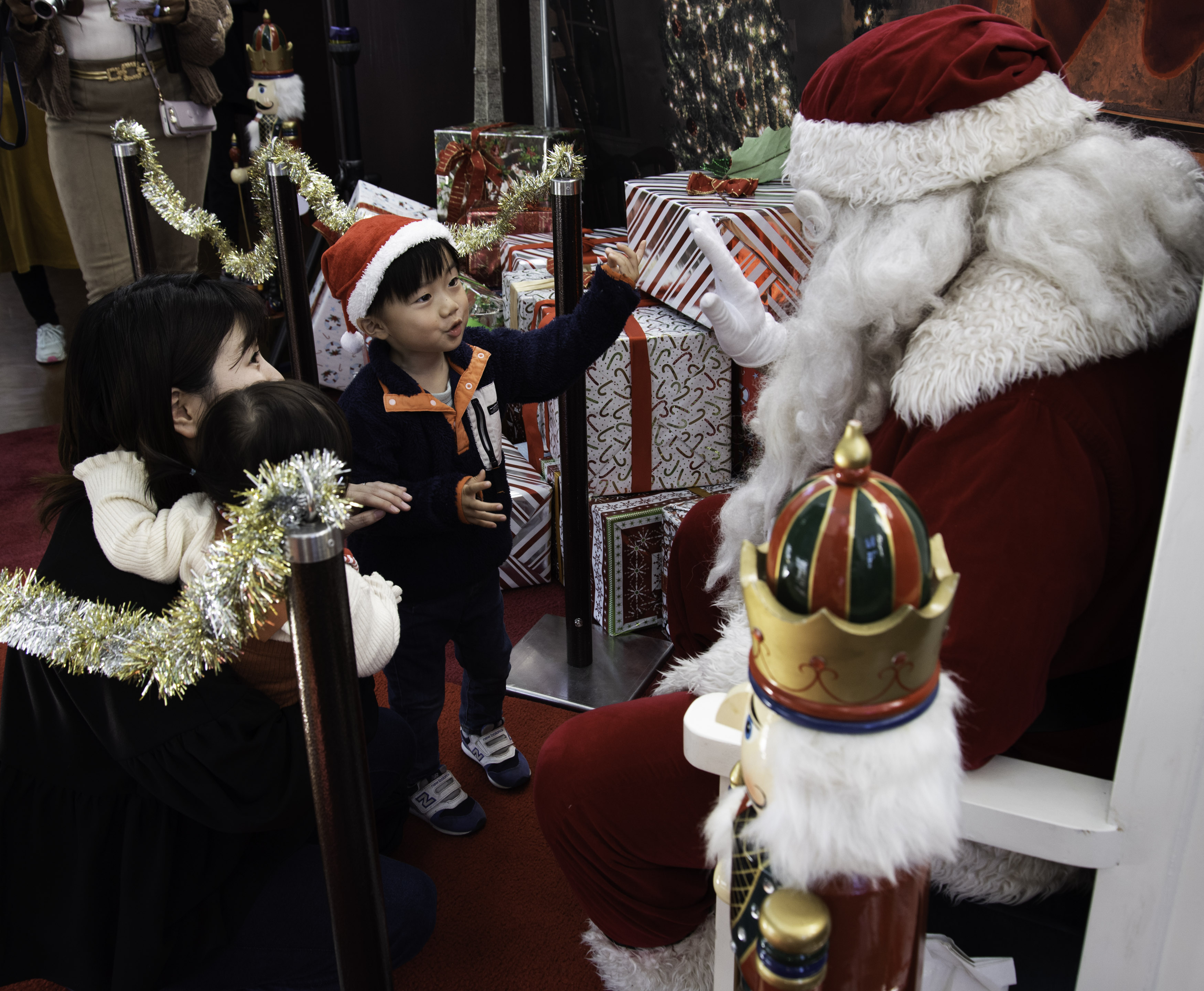 Child high fives Santa Claus at CFAY Festival of Trees December 9, 2023