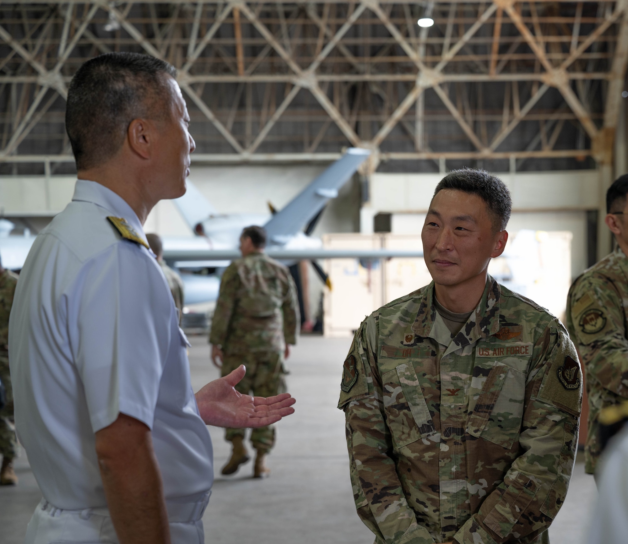 Colonel Jun Oh of the 374th Operation Group, speaks with Rear Admiral Onishi, Commander of fleet Air Wing 1, after the 319th Expeditionary Reconnaissance Squadron transition ceremony at Japan Maritime Self-Defense Force Kanoya Air Base, Oct. 13, 2023.