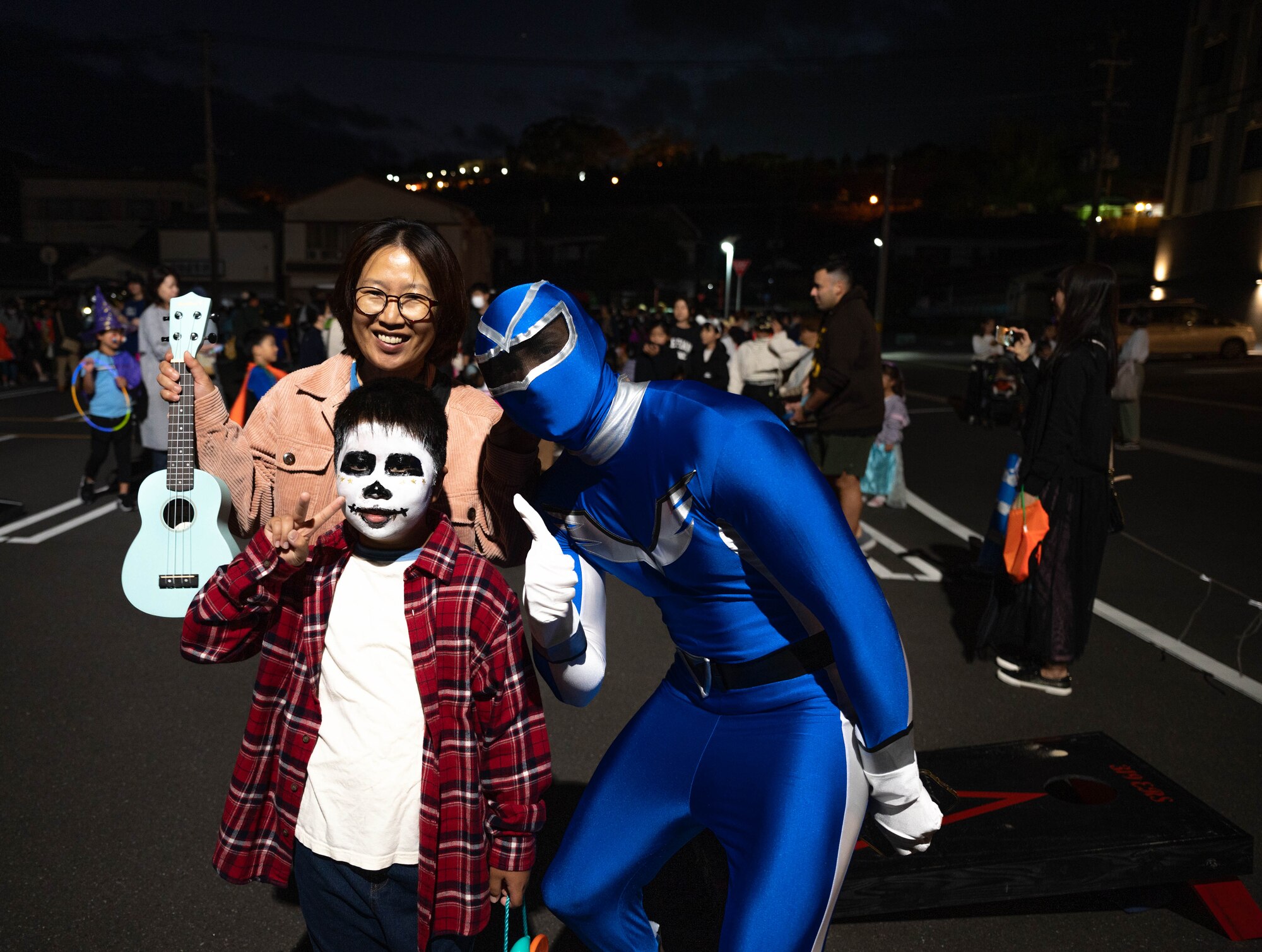 Capt. Miguel Molas, Kadena 319th Expeditionary Reconnaissance Squadron, director of operations, teaches Japanese nationals how to play cornhole during the Trunk-or-Treat event at Kanoya, Japan, Oct. 13th 2023.