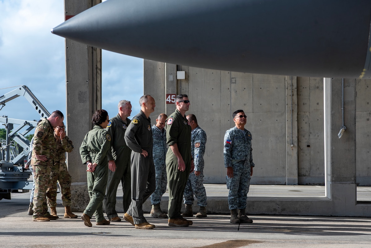 military members look at a fighter plane