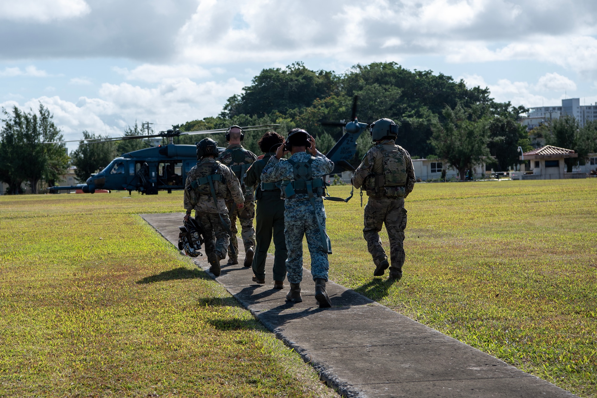 military members walk towards a helicopter