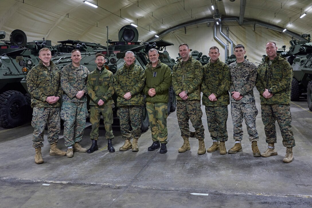 Norwegian military leaders and U.S. Marines assigned to U.S. Marine Corps Forces Europe and Africa and Combat Logistics Battalion 6, pose for a photo during a tour of the motor pool in Vaernes, Norway on Dec. 7, 2023. During the visit, U.S. Marine Corps Maj. Gen. Robert B. Sofge Jr., commander of MFEA, participated in leadership discussions with key Norwegian partners, cultivating bilateral cooperation in support of ongoing Marine Corps operations within Norway. (U.S. Marine Corps photo by Lance Cpl. Mary Linniman)