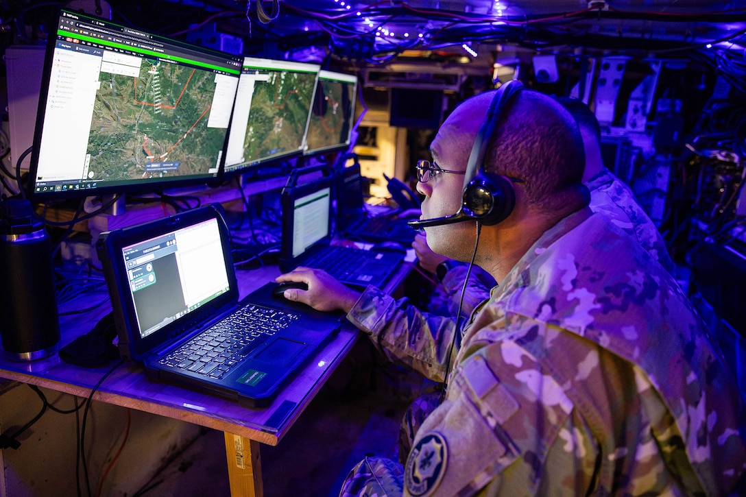 A soldier reviews map locations on a laptop.