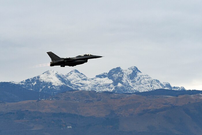 A U.S. Air Force F-16 flies over mountains