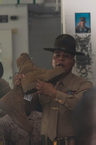 U.S. Marine Corps Staff Sgt. Douglas R. Perez, drill instructor with India Company, 3rd Recruit Training Battalion, gives instructions during pick up at Marine Corps Recruit Depot, San Diego, Dec. 1, 2023. Recruits were introduced to their drill instructors, where they gained an understanding of the rules and expectations set for their training. (U.S. Marine Corps photo by Lance Cpl. Janell B. Alvarez)