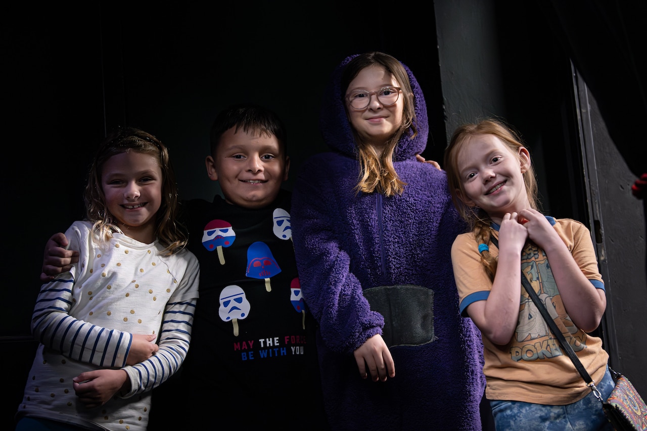 Four children smile and pose for the camera.