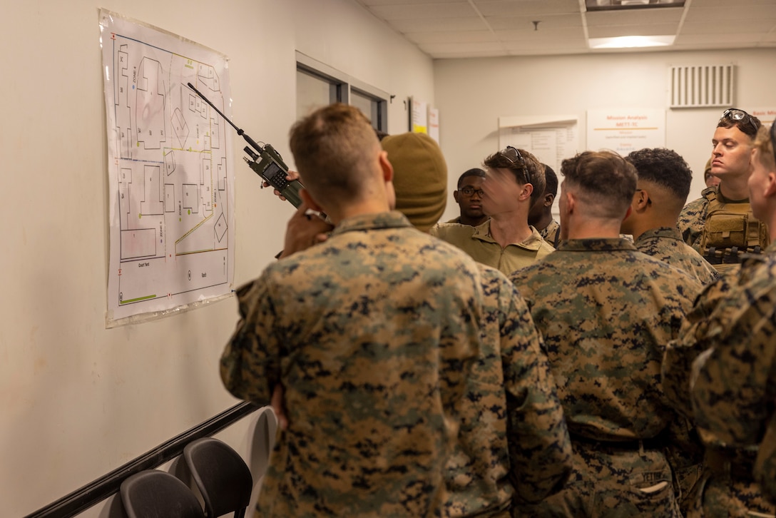 A critical skills operator with Marine Forces Special Operations Command briefs Marines from Battalion Landing Team 1/8 prior to a joint raid during an integration training event on Camp Lejeune, North Carolina, Nov. 21, 2023. MARSOC worked with Marines from BLT 1/8 to increase interoperability with the Fleet Marine Force. (U.S. Marine Corps photo by Cpl. Henry Rodriguez)