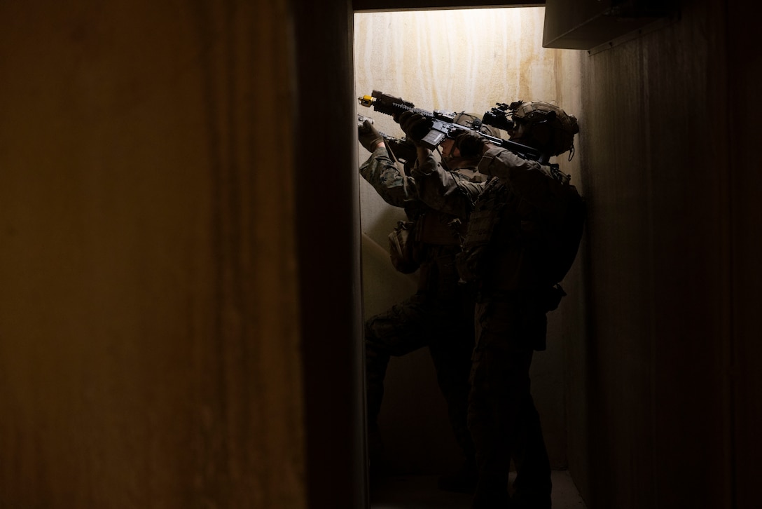 A U.S. Marine with Battalion Landing Team 1/8, clears a stairwell with a critical skills operator from Marine Forces Special Operations Command during an integration training event on Camp Lejeune, North Carolina, Nov. 21, 2023. MARSOC worked with Marines from BLT 1/8 to increase interoperability with the Fleet Marine Force. (U.S. Marine Corps photo by Cpl. Henry Rodriguez)