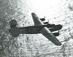 The crisp, clear black- and white-photograph of a PB4Y-1 “Liberator” airplane viewed from its starboard side, flying over the Bay of Biscay in November 1943