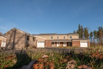 Photo of a two story condominium homes with a brick facade and tan siding.