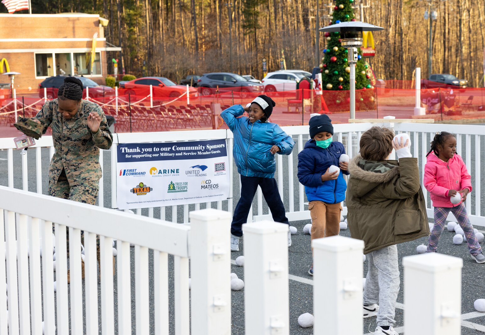 U.S. Marines and their families partake in a snowball fight during the annual Quantico holiday tree lighting at the Marine Corps Exchange parking lot on Marine Corps Base Quantico, Virginia, Dec. 7, 2023. The festivities included a roller-skating rink, snowball fighting, games for children, music performances, and vendor booths all to celebrate the holiday season. (U.S. Marine Corps Photo by Lance Cpl. Kayla LeClaire)