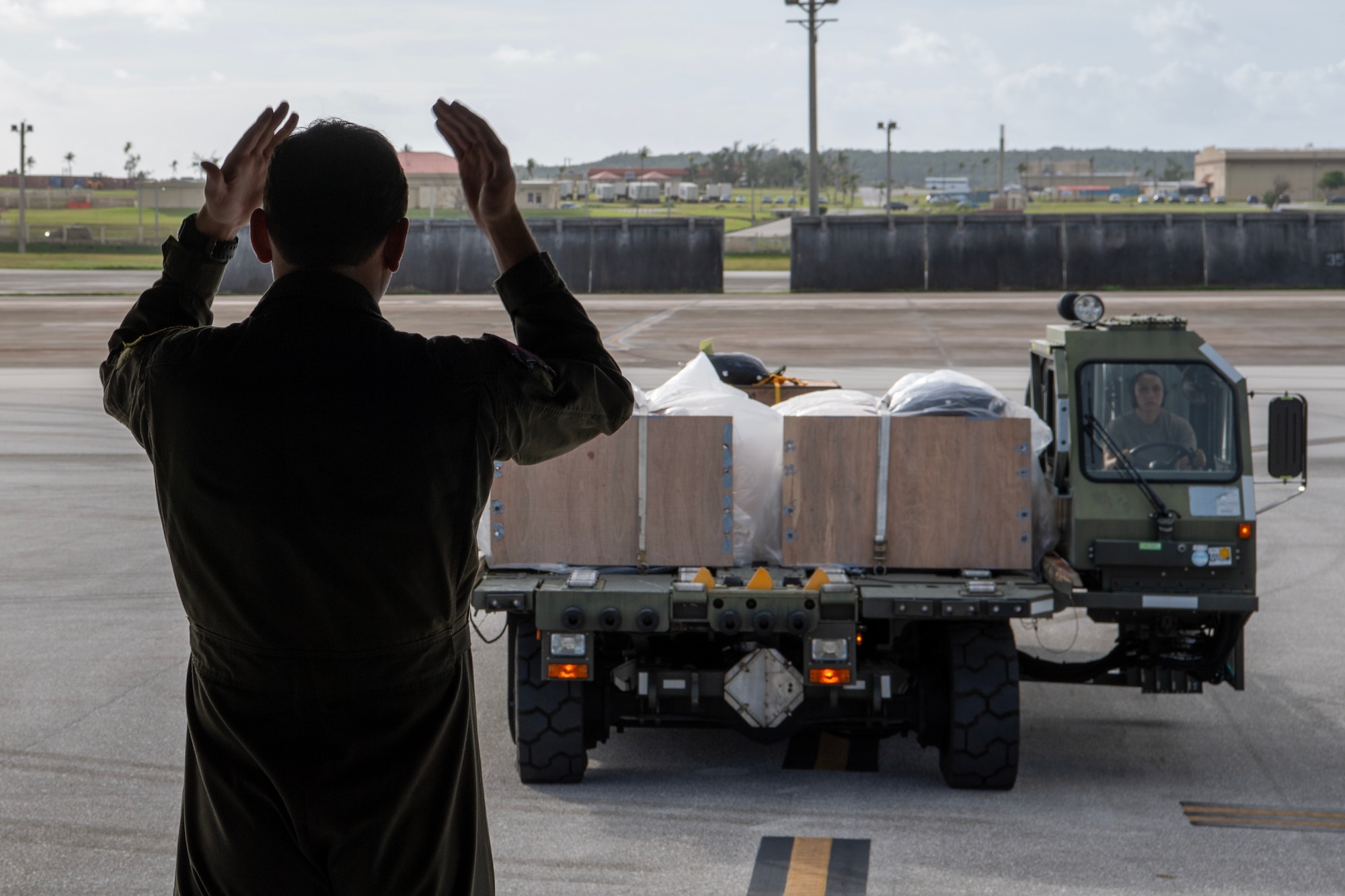 Photo of U.S. Air Force loadmaster guiding a cargo loader to the back of an aircraft
