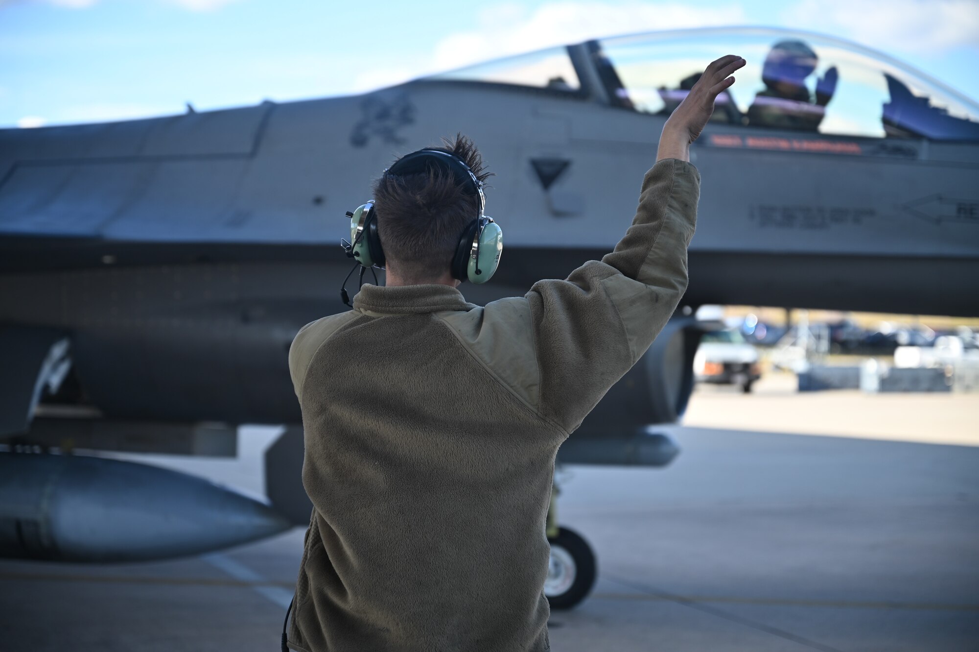 maintainer does tiger claws toward pilot taxiing